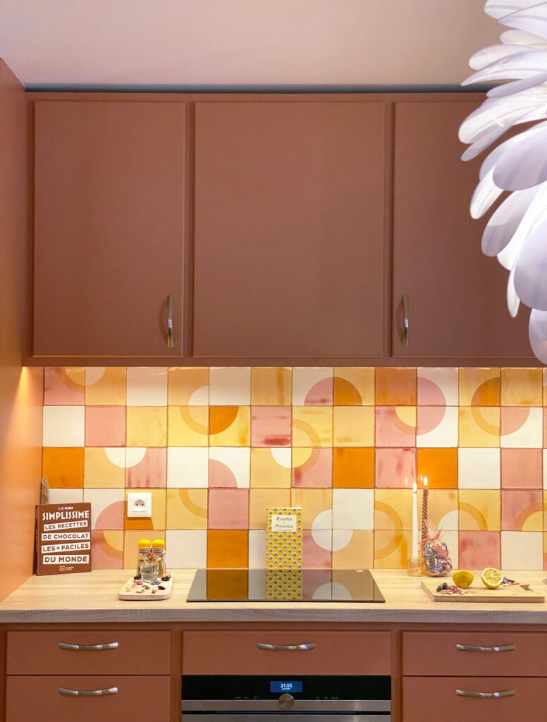Kitchen splashback of Smink Studio handmade ceramic tiles in terracotta, pink, mustard and cream half-circle screen-printed colours, with terracotta cabinets.